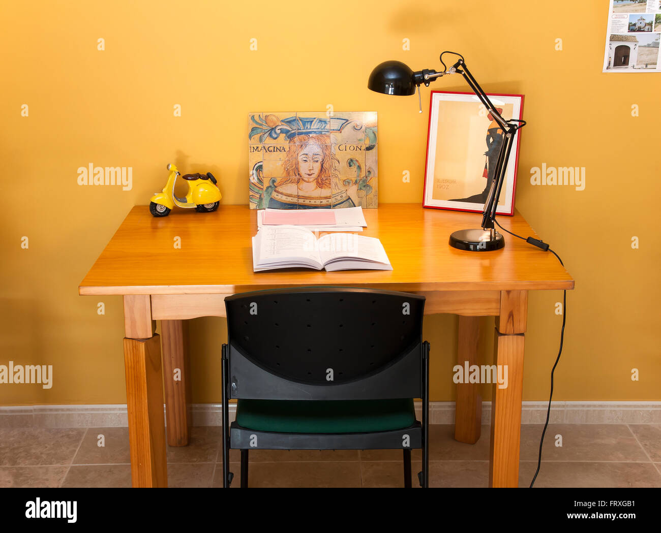 Scrivania in legno in ufficio con un libro e una lampada Foto Stock