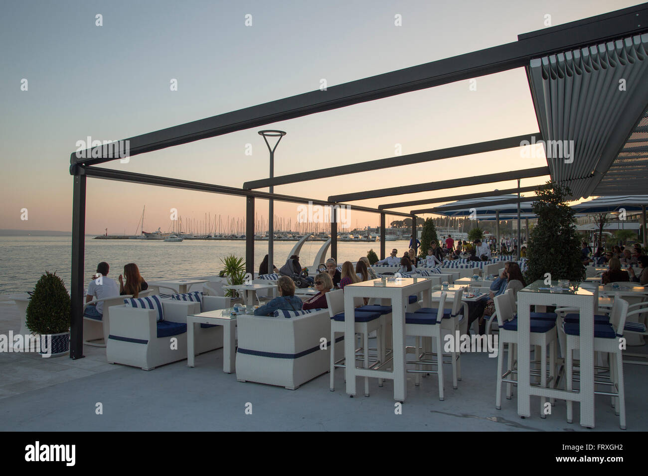 Le persone al di fuori seduta a un bar sul lungomare, Split, Split-Dalmatia, Croazia Foto Stock