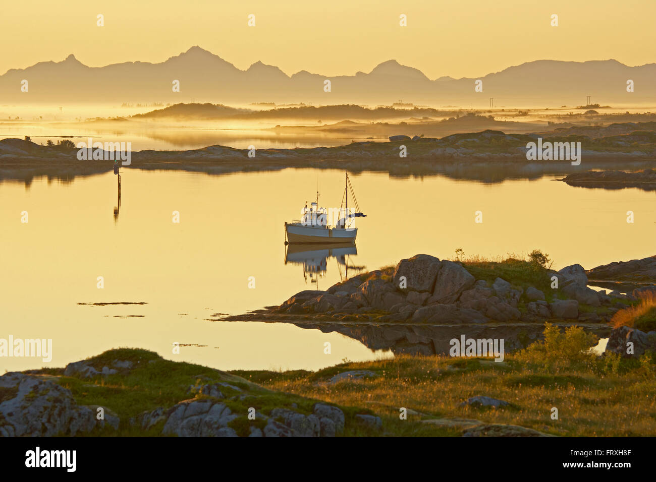 Del pescatore in barca il sole di mezzanotte vicino Lyngvaer, Isola di Austvagoy, Lofoten, Provincia del Nordland, Nordland, Norvegia, Europa Foto Stock