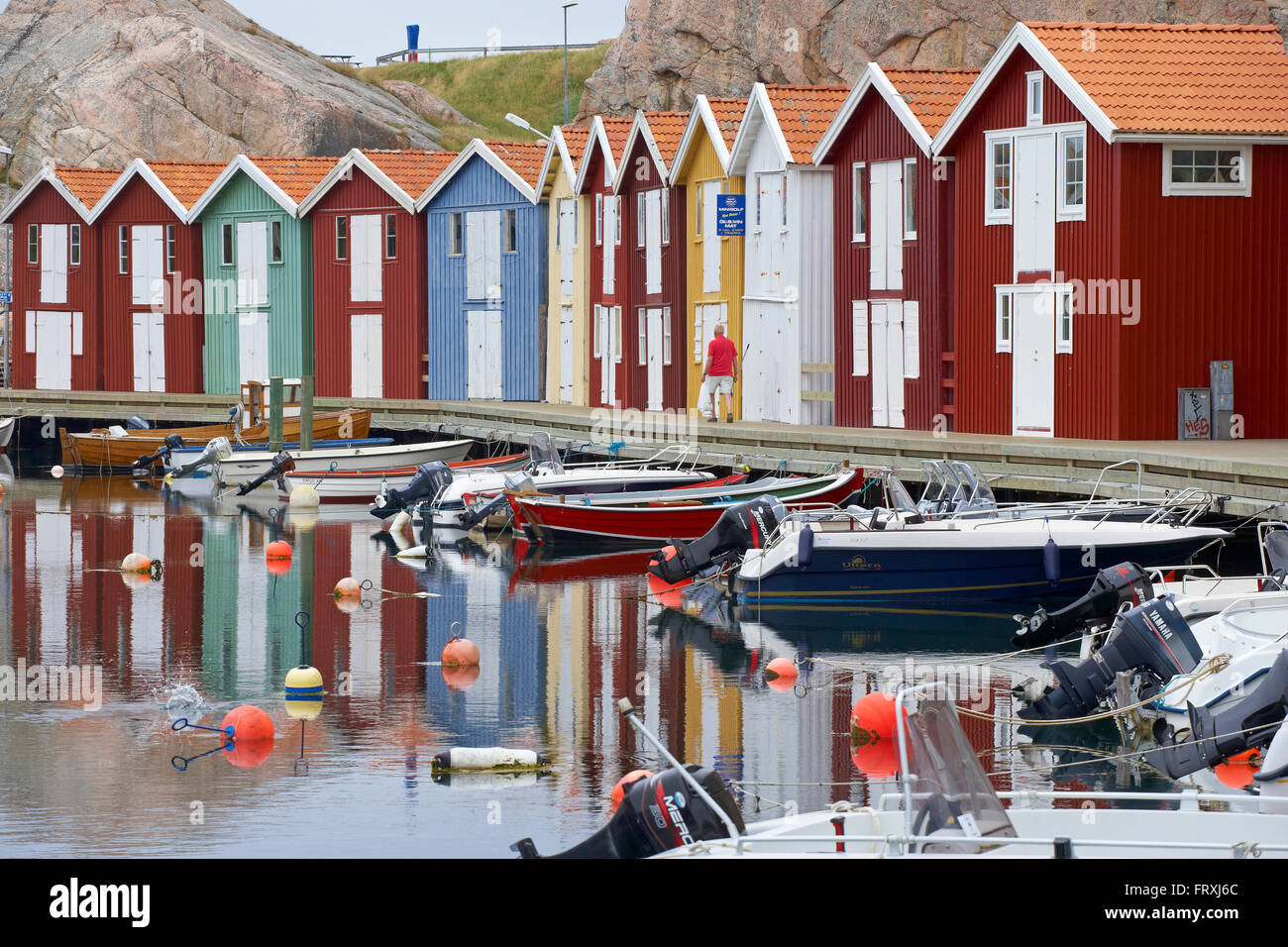Barche e case in barca nel porto di Smoegen, riflesso nell'acqua, Sotenas Penisola, Provincia di Bohuslaen, nella costa occidentale della Svezia, Europa Foto Stock