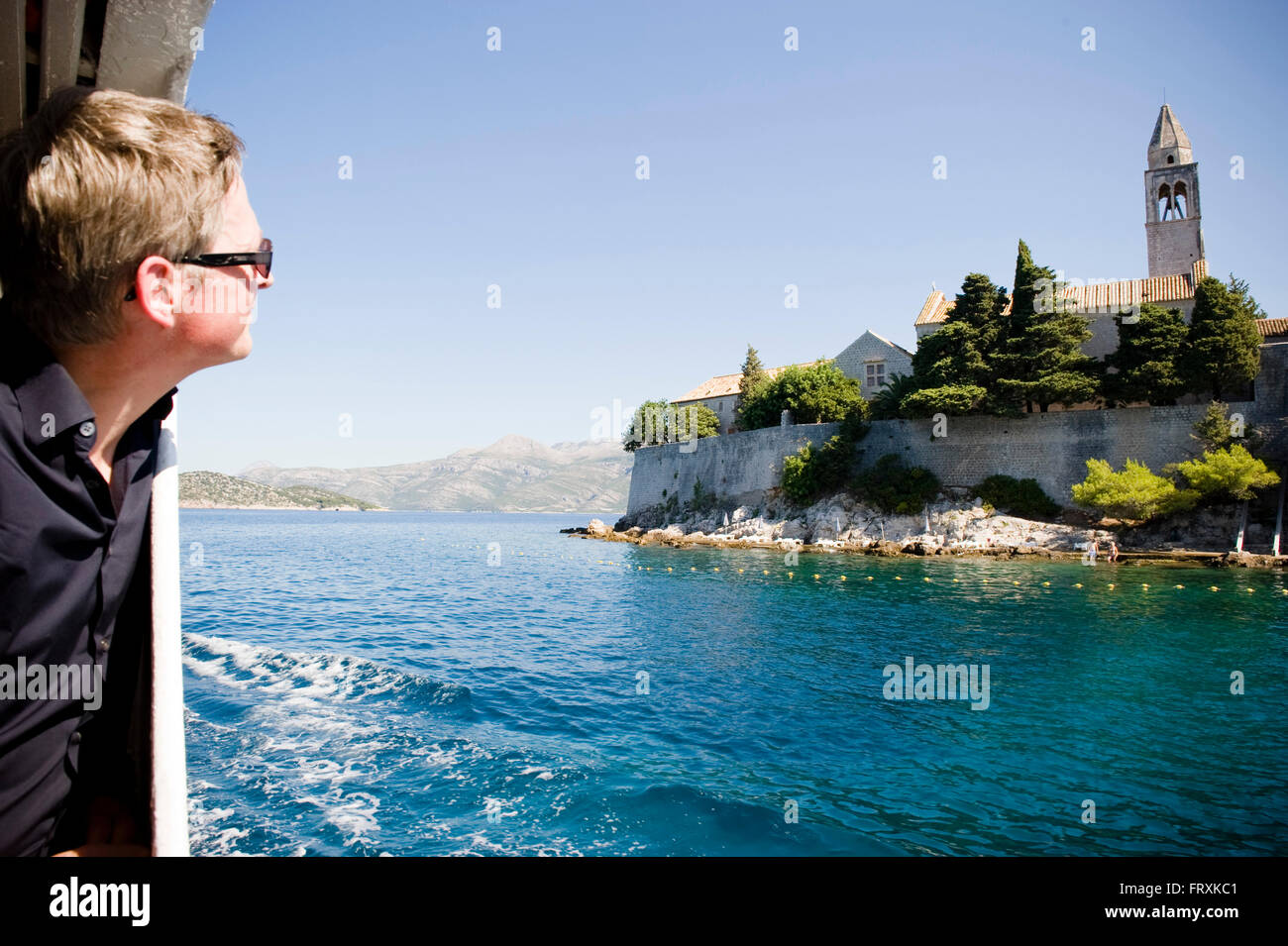 Un uomo su un traghetto guardando il monastero francescano, Lopud, Elaphites, Dubrovnik-Neretva, Croazia Foto Stock