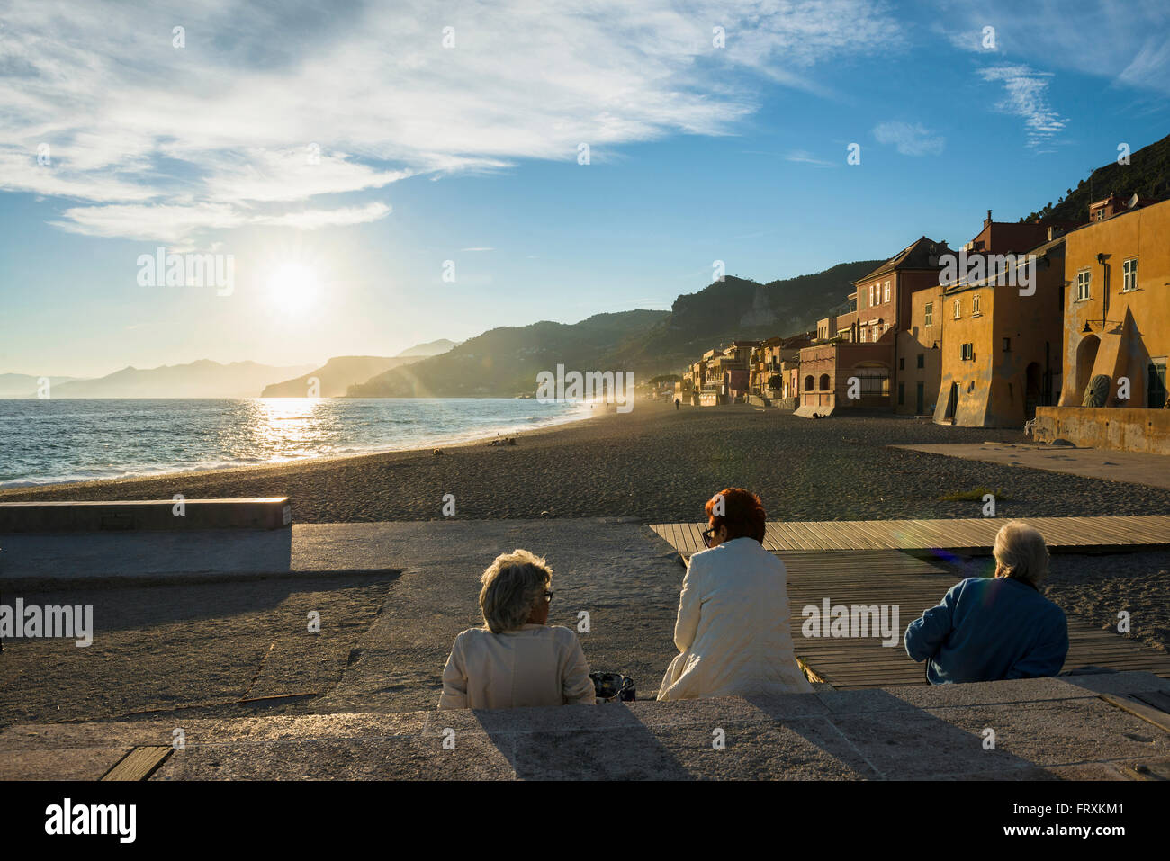 Persone che guardano al tramonto in spiaggia, Varigotti, Finale Ligure, in provincia di Savona Liguria, Italia Foto Stock