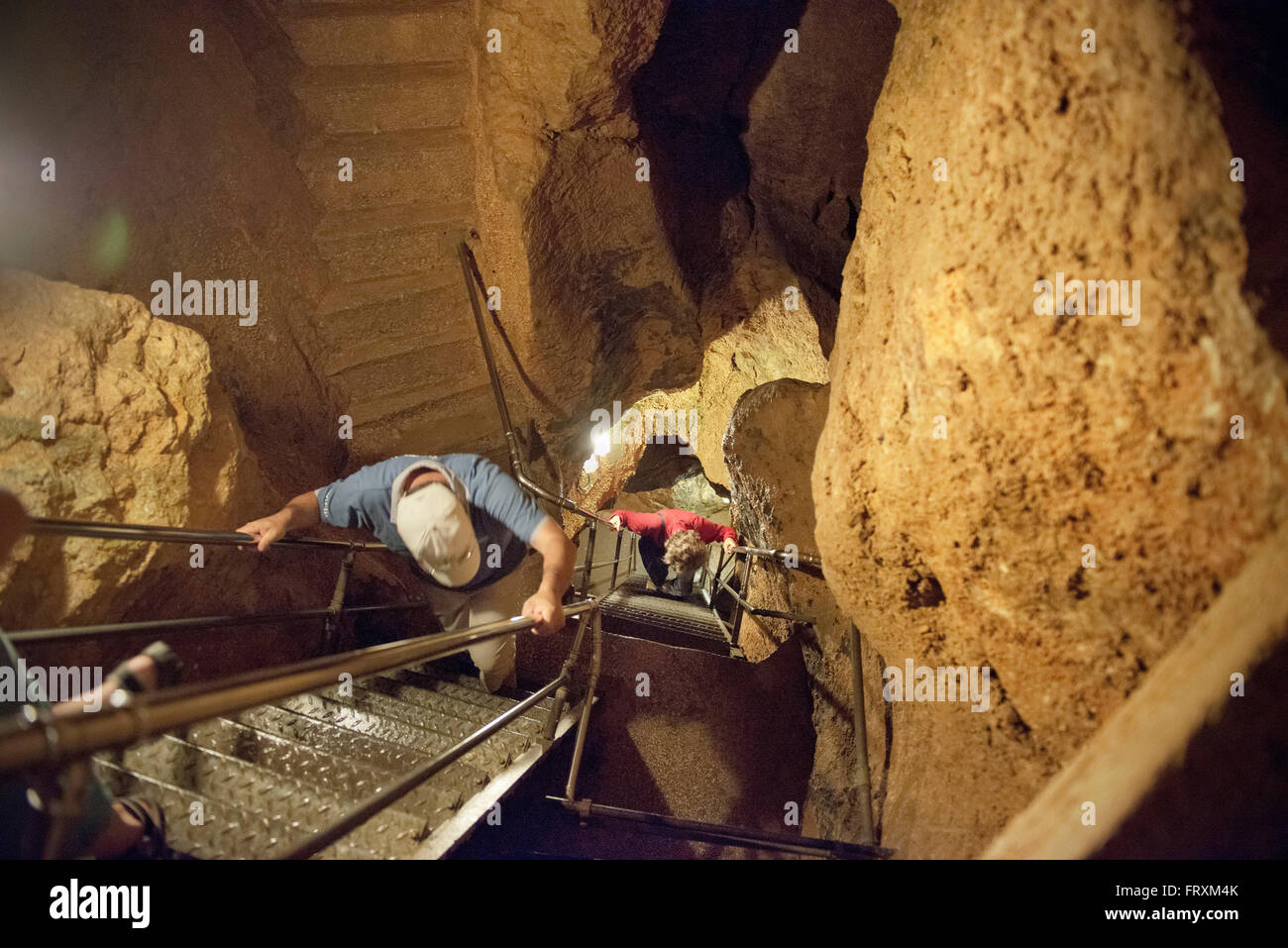 I visitatori la scalata verso il basso in una profonda grotta, Laichinger Tiefenhoehle, Laichingen, Svevo Alp, Baden-Wuerttemberg, Germania Foto Stock