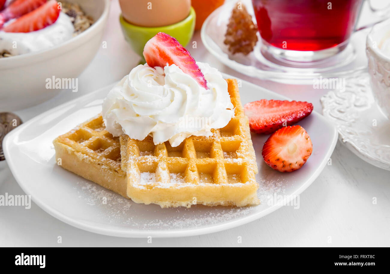 La prima colazione dolce con cialde, crema e fragole Foto Stock