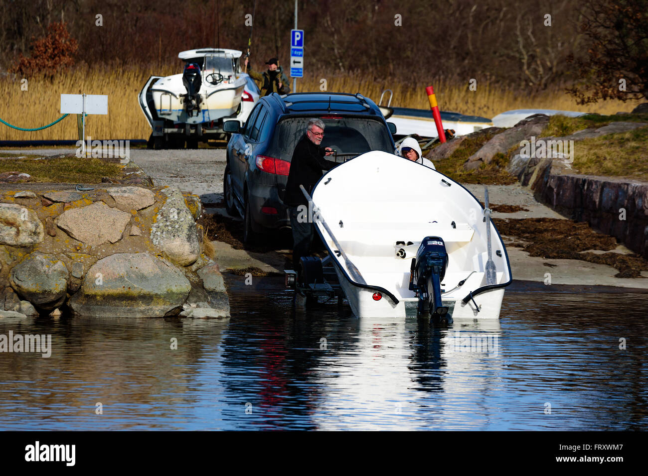 Torhamn, Svezia - 18 Marzo 2016: il lancio di un piccolo di plastica con una barca a motore ad una rampa nella marina. Barca è caricato un trai Foto Stock