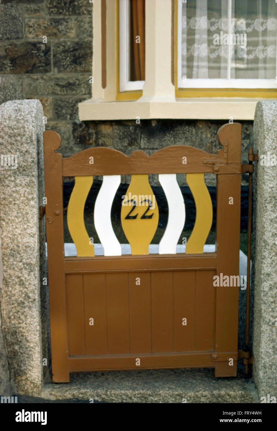 Verniciato di colore marrone anni trenta cancello in legno nella parete di fronte giardino del cottage Foto Stock
