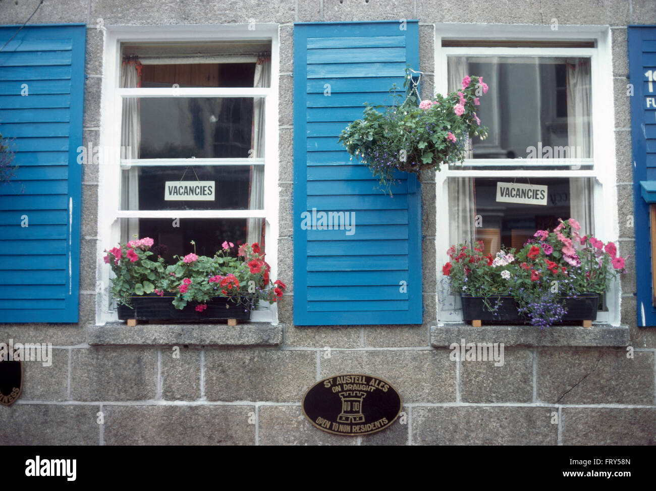 Close-up di Windows di settanta cottage B+B con scatole di finestra blu e persiane louvre Foto Stock