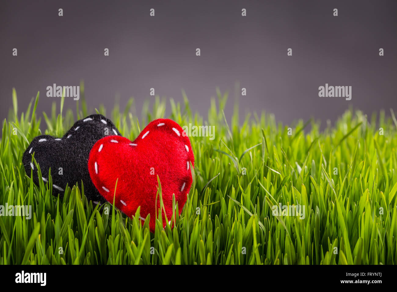 Realizzato a mano di colore rosso e nero cuori in feltro Foto Stock