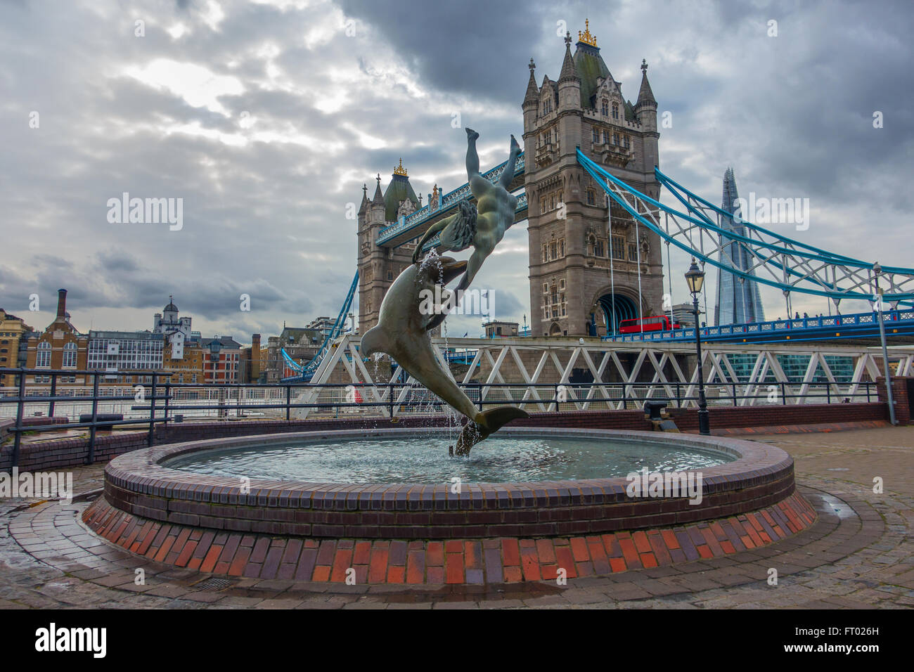 La ragazza e la fontana dei Delfini di Tower Bridge City of London Foto Stock