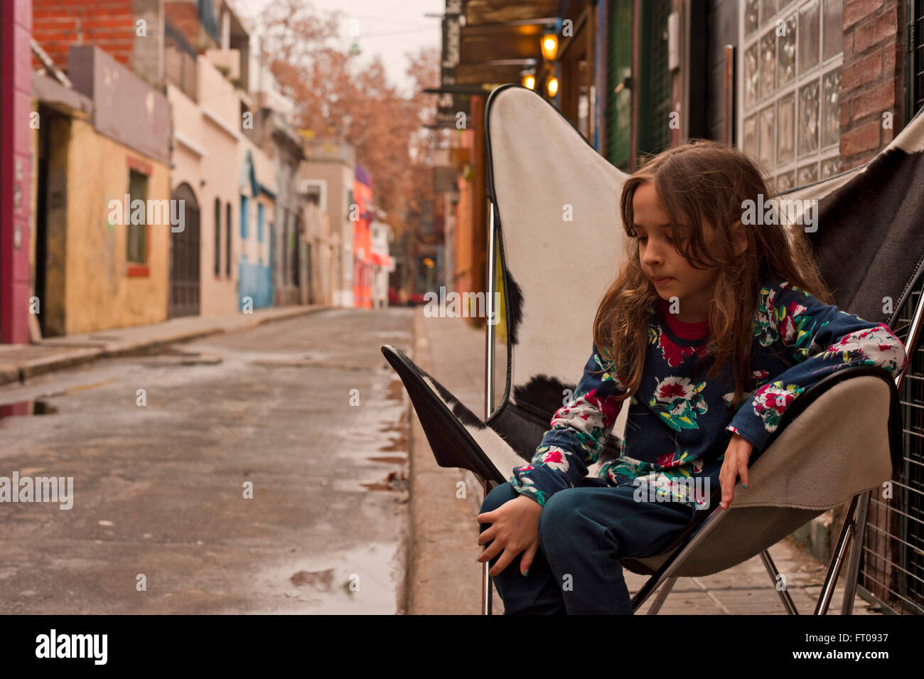 Ragazza pensierosa seduta su sedia in pelle, Buenos Aires Foto Stock
