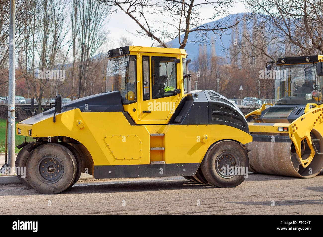 I veicoli della costruzione della strada, giallo rullo su strada. Foto Stock
