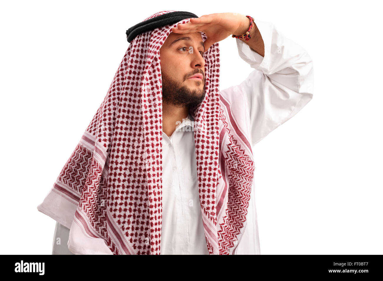 Giovane Arabo con un velo a scacchi guardando in lontananza e ombreggiatura i suoi occhi con la sua mano isolati su sfondo bianco Foto Stock