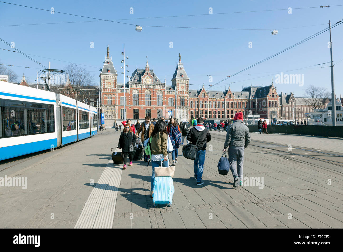 La stazione ferroviaria centrale di Amsterdam e viaggiatori con bagaglio vicino tram sulla giornata di sole Foto Stock