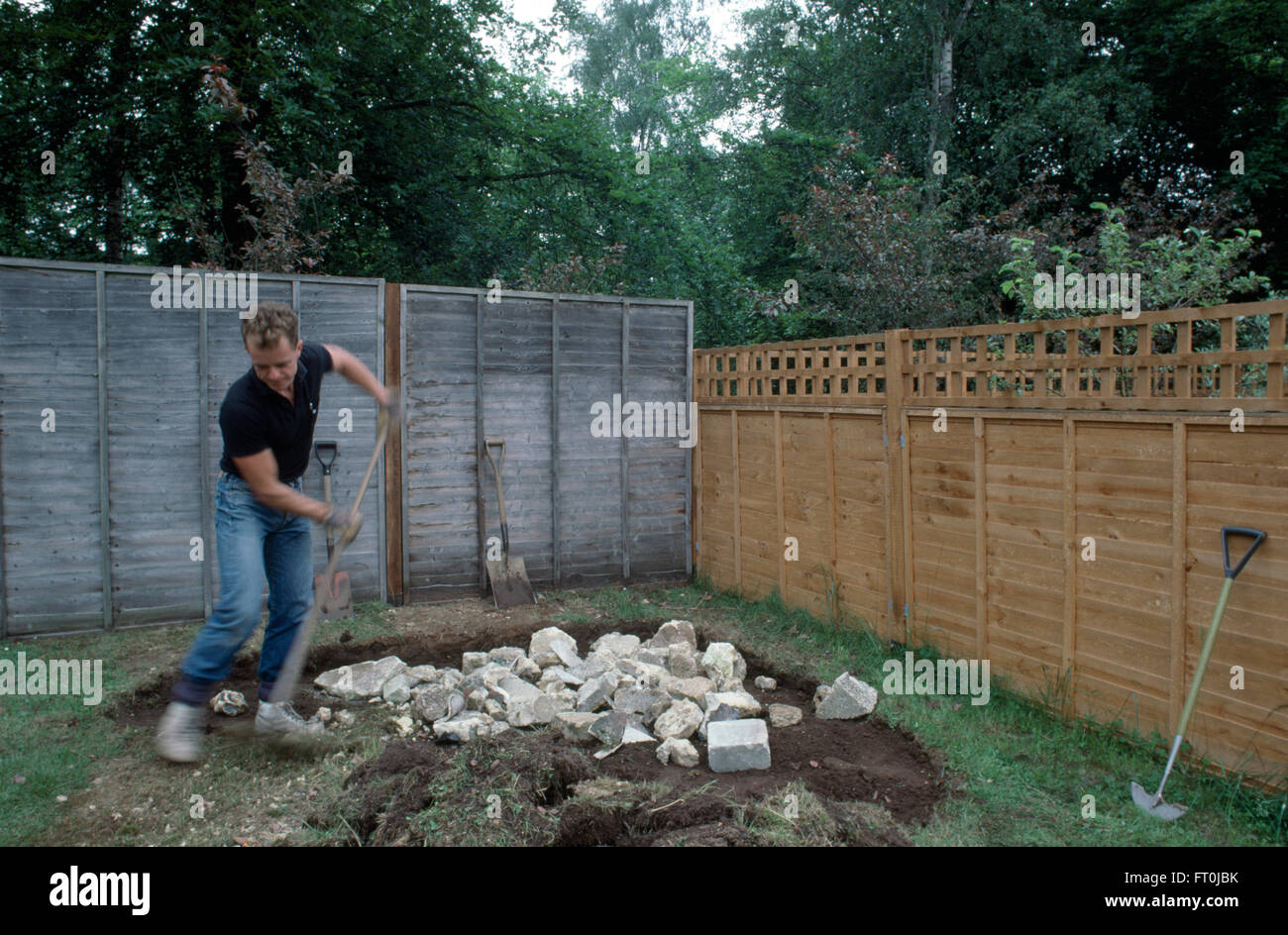Giardiniere facendo una rockery in un nuovo giardino per il solo uso editoriale Foto Stock
