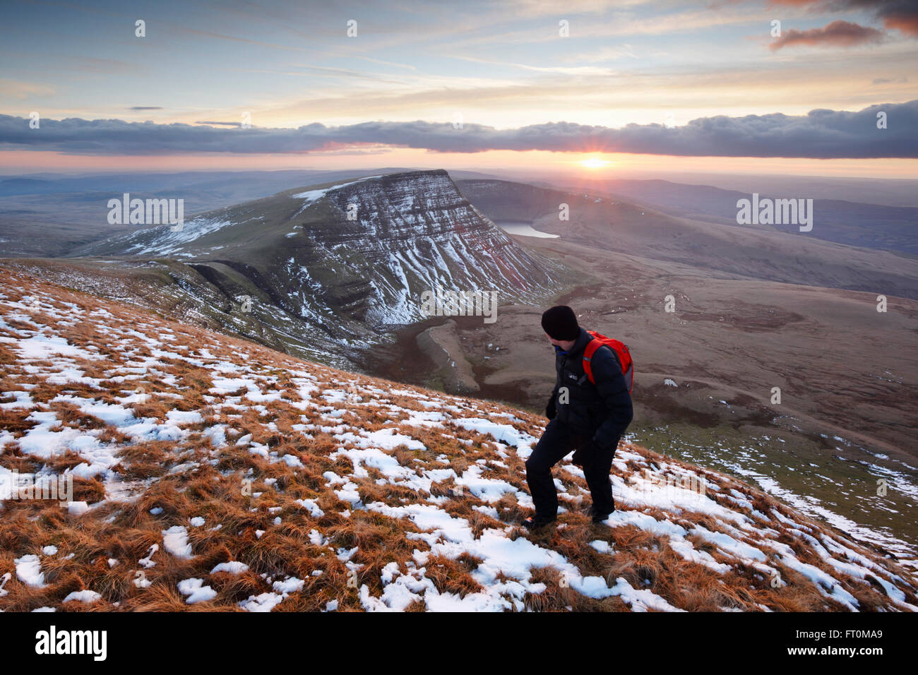 Hillwalker salire la montagna nera al tramonto. Parco Nazionale di Brecon Beacons. Carmarthenshire. Il Galles. Regno Unito. Foto Stock