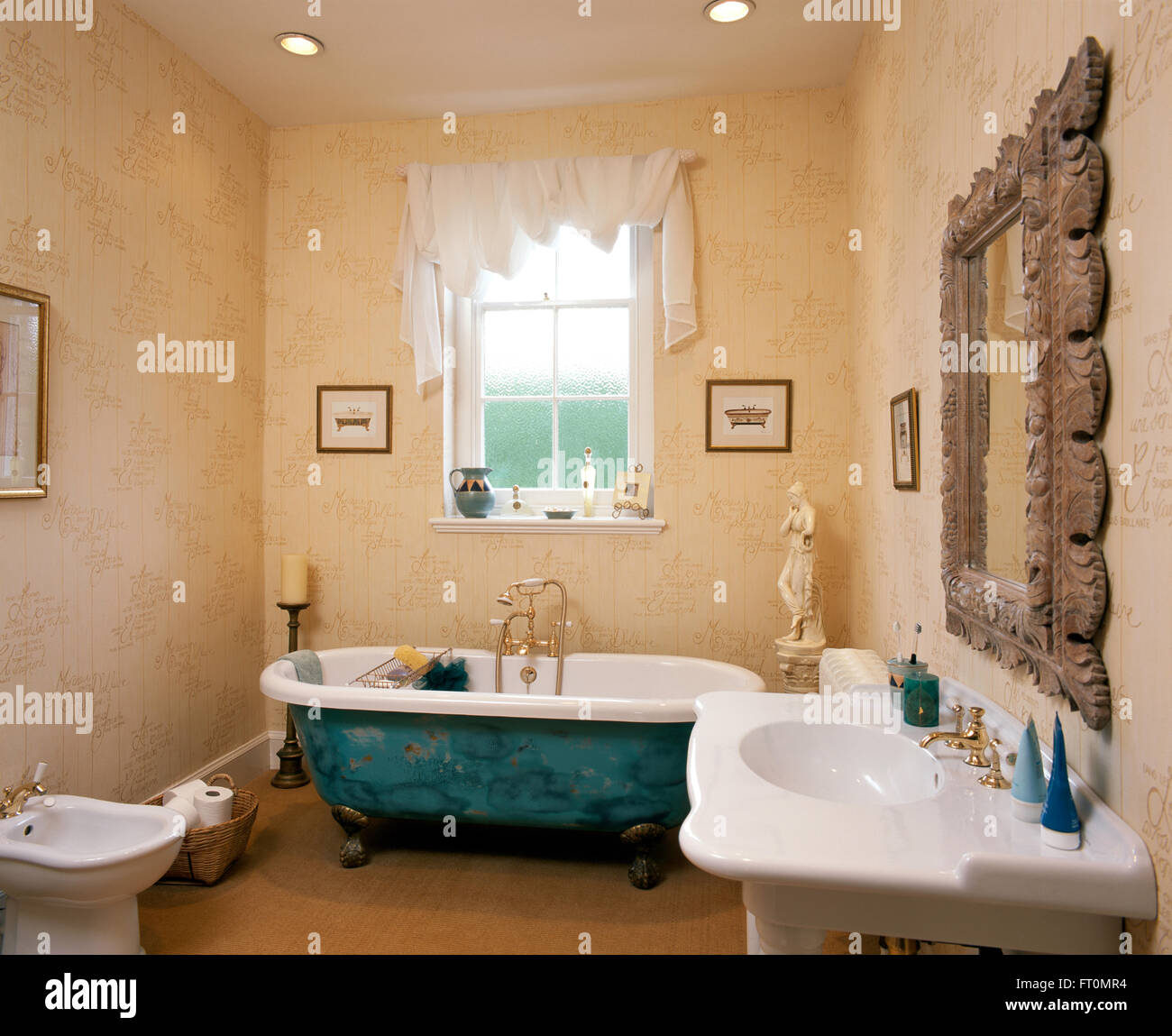 Bianco tessuto drappeggiato sul polo sulla finestra sopra un dipinto decorativamente roll top bagno in un bagno con una spugnatura effetto vernice Foto Stock