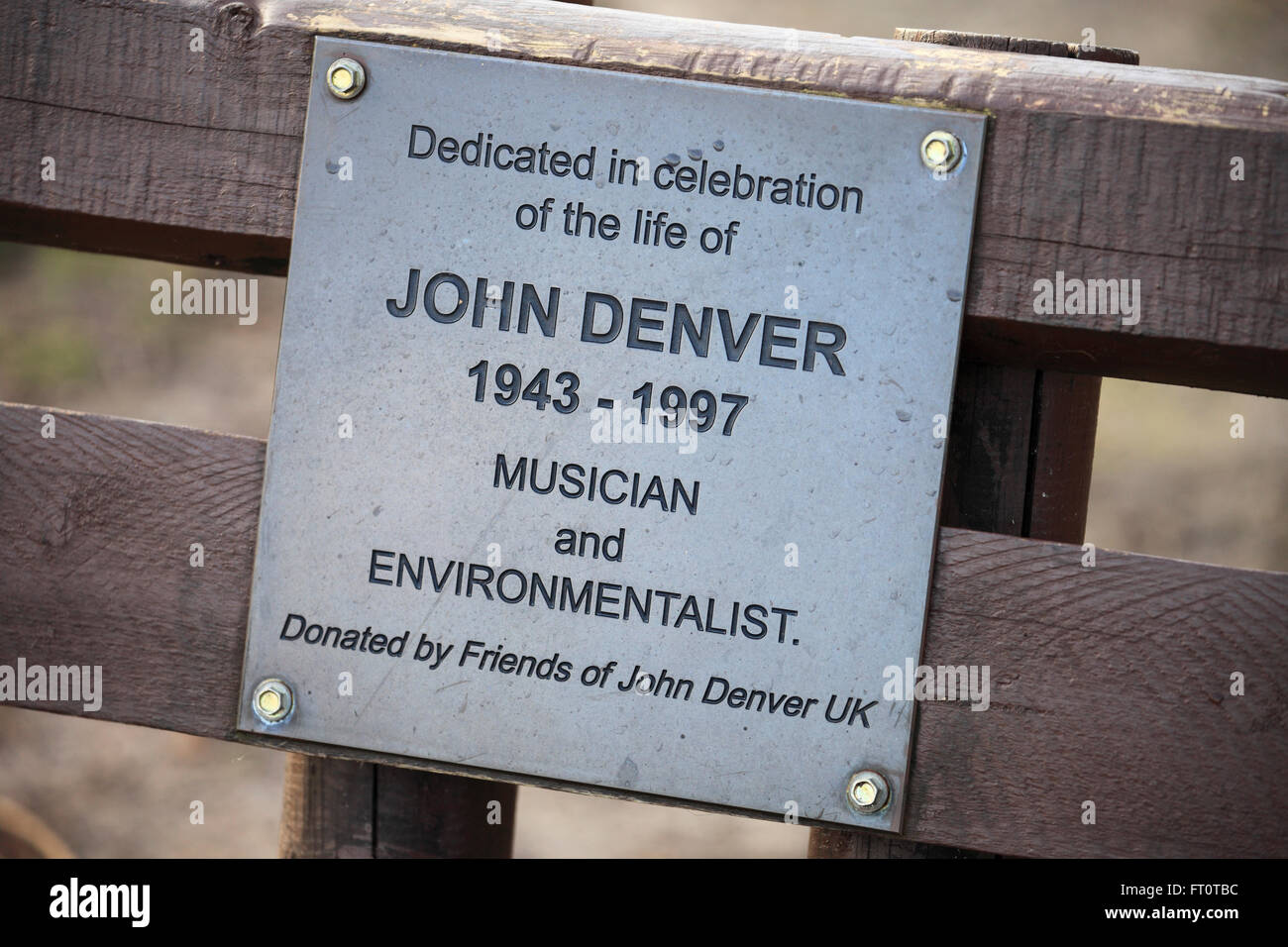 Un banco di lavoro con una dedizione piastra per il musicista John Denver. A Dersingham Bog nella Riserva Naturale del Norfolk. Foto Stock