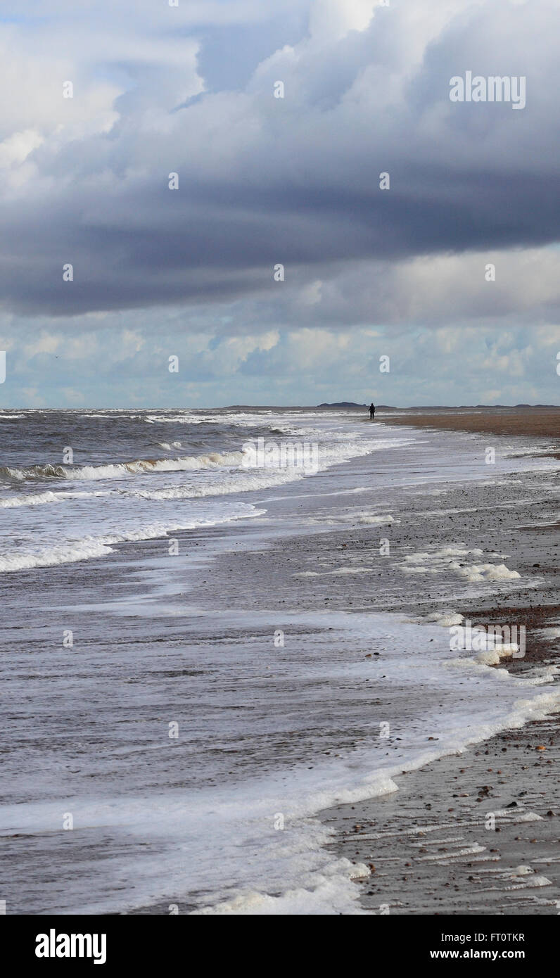 La spiaggia di Thornham sulla costa di Norfolk con una singola figura distante. Foto Stock
