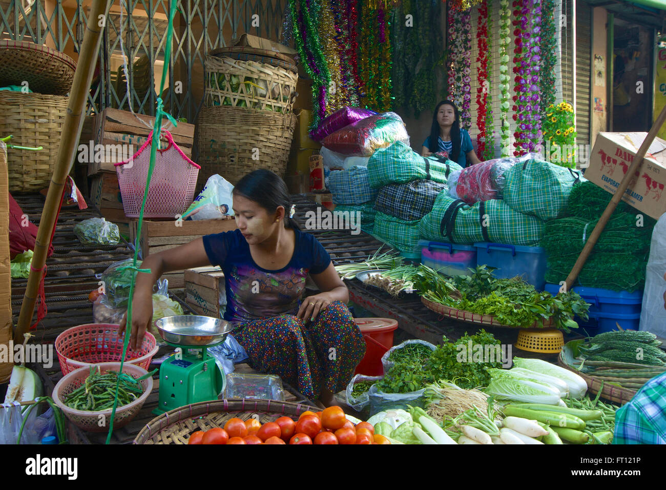 La donna a un vegetale street stallo, mercato a Yangon, Rangoon, capitale del Myanmar Birmania Foto Stock