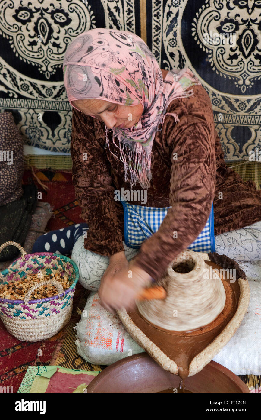 Donna che produce olio di argan, Essaouira, Marocco Foto Stock