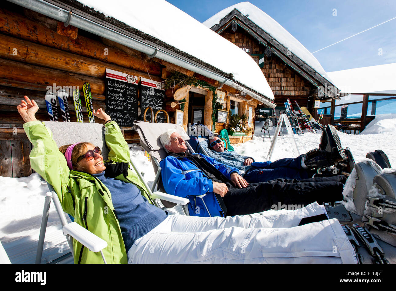 Tre gli sciatori a prendere il sole davanti a un rifugio sciistico, Fageralm, Salisburgo, Austria Foto Stock