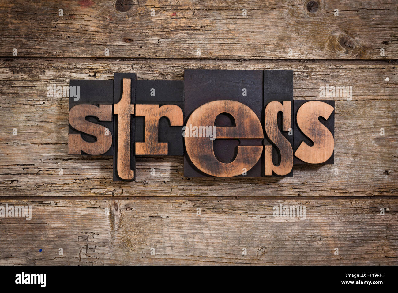 Stress, parola scritta con l'annata tipografia su blocchi di legno rustico sfondo Foto Stock