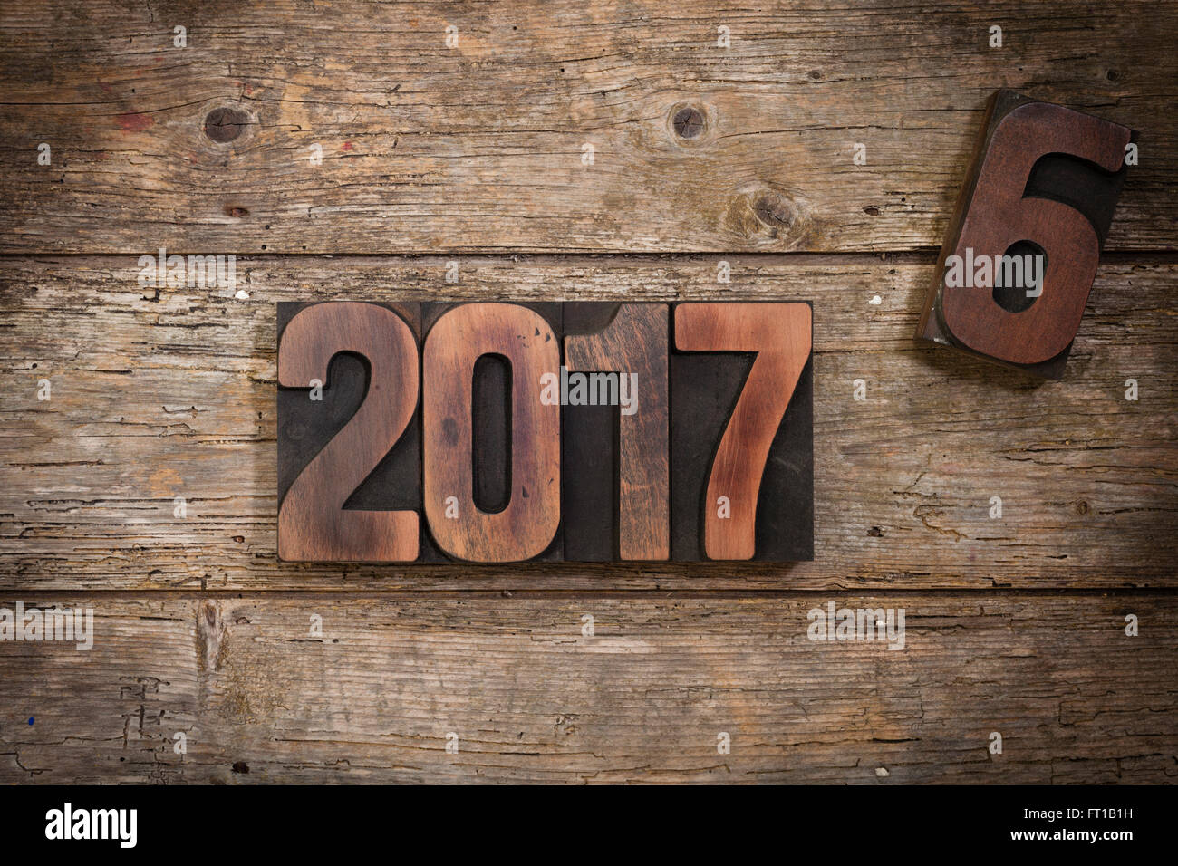 Ruotare dell'anno 2016 al 2017 raffigurata con vintage Stampa tipografica Stampa numeri di blocco sul rustico sfondo di legno Foto Stock