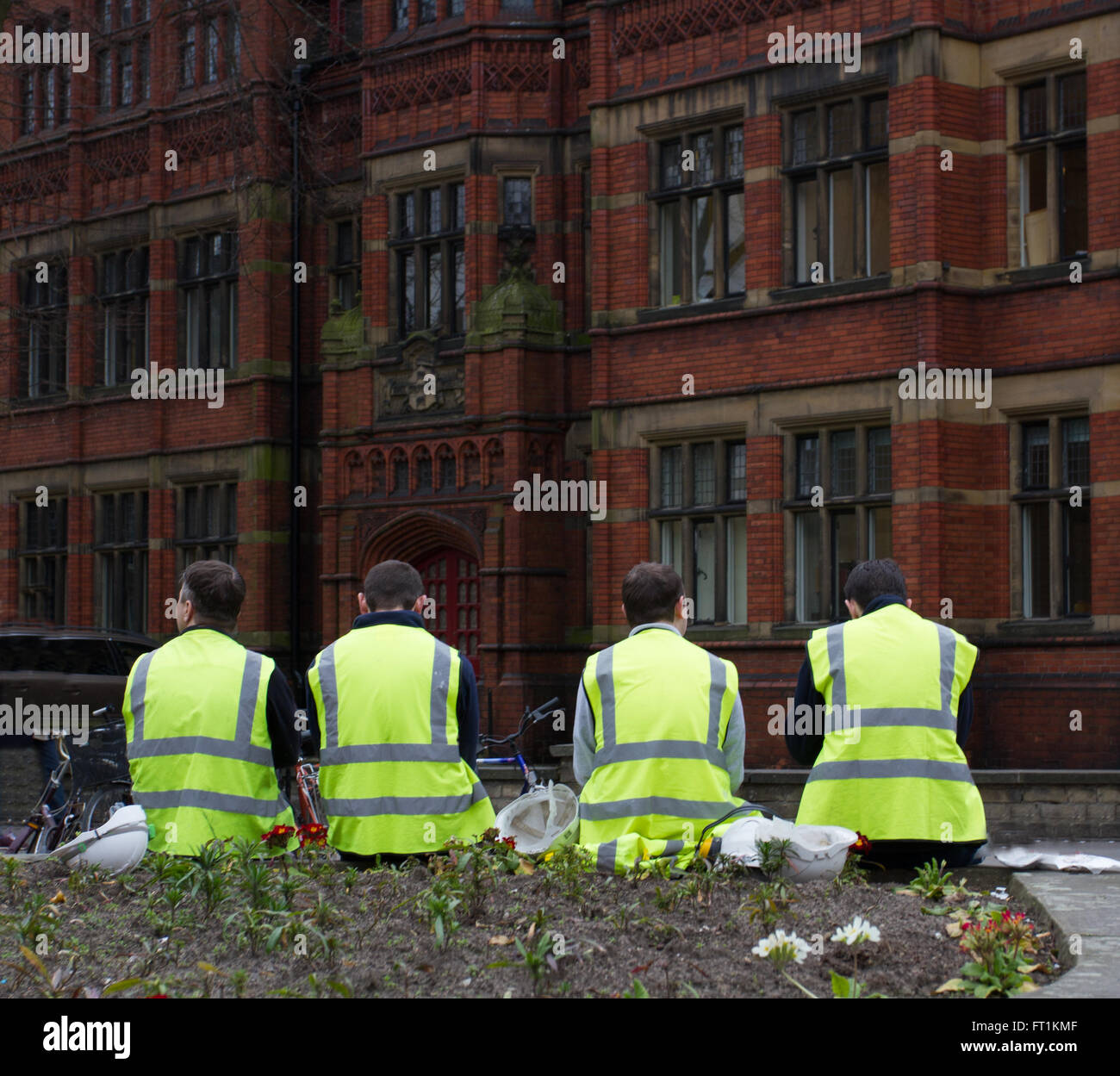 Quattro lavoratori edili in alta visibilità abbigliamento seduti sulle strade di york durante una pausa nel lavoro. Foto Stock