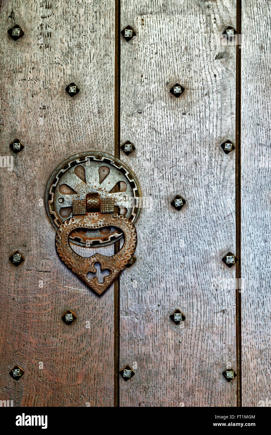 Costellata porta in legno di quercia e la maniglia in San Giovanni Evangelista Chiesa, Elkstone, Gloucestershire, Cotswolds, Inghilterra Foto Stock