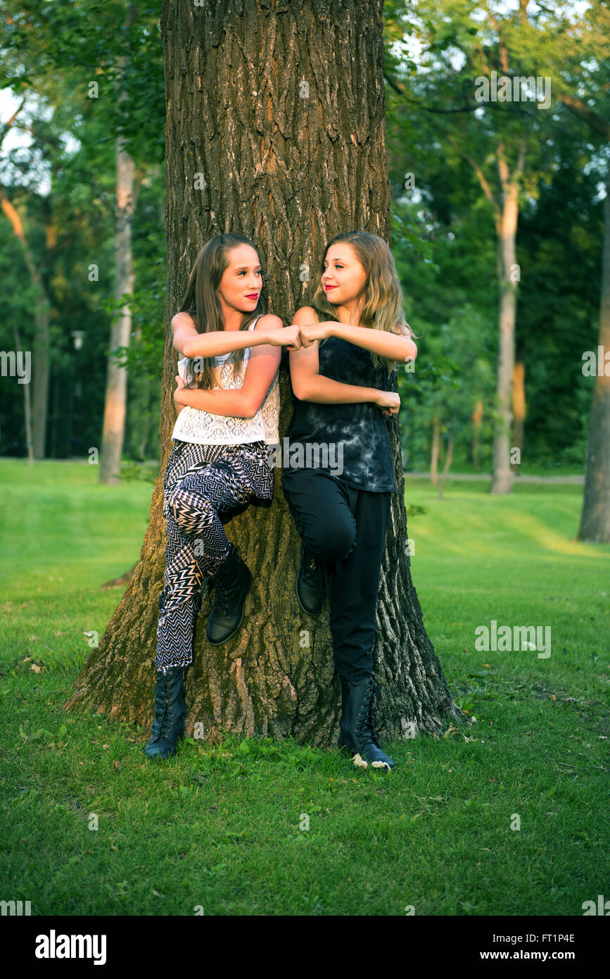 Una coppia di giovani adolescenti amico migliore ragazze danno un pugno pompa in un parco all'aperto impostazione Foto Stock