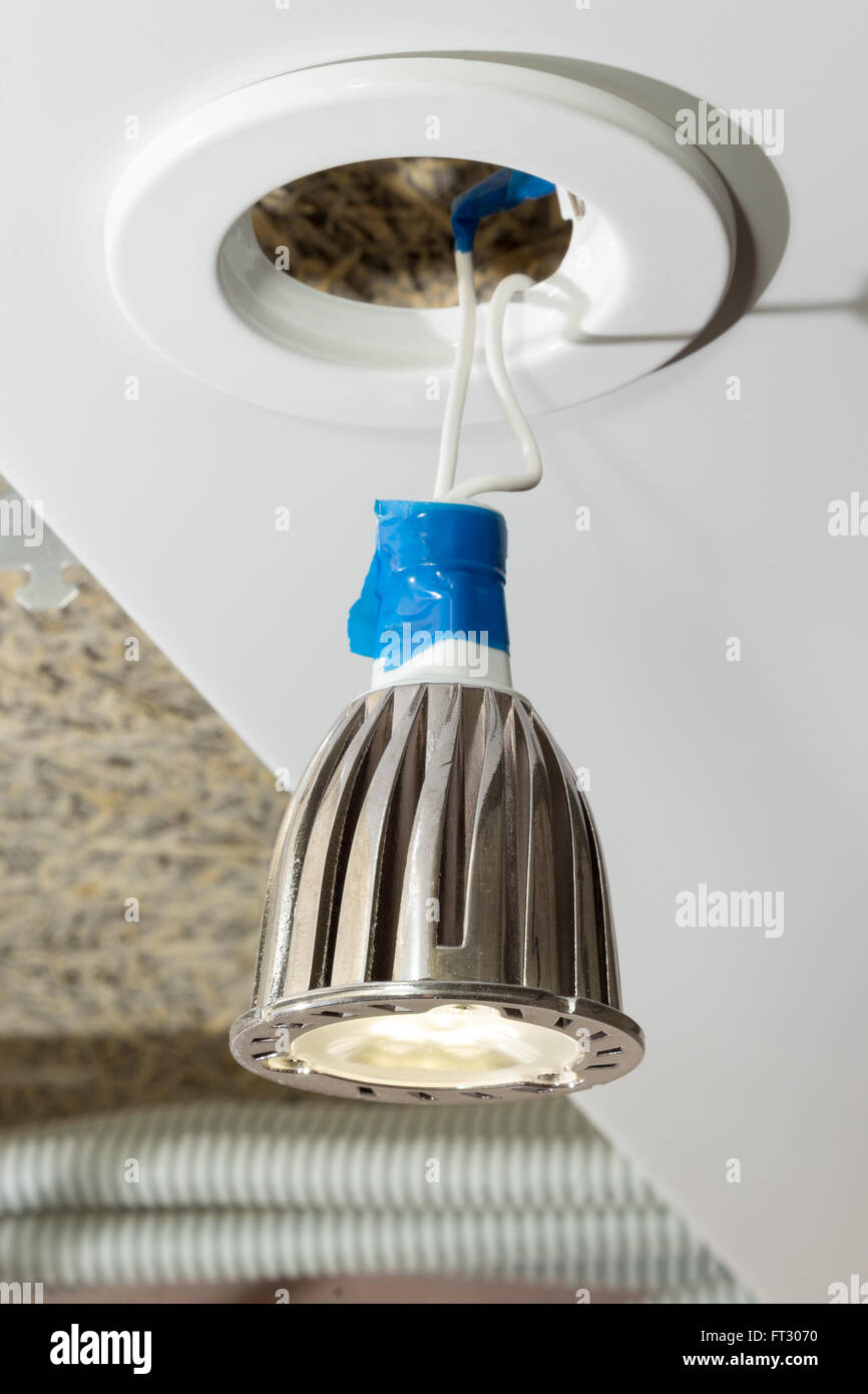 Luce LED lampadina pende da una macchia sui fili Foto Stock