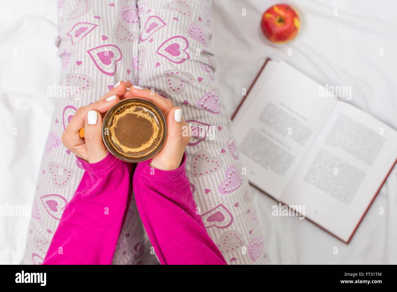 Donna con una tazza di caffè al mattino nel letto Foto Stock