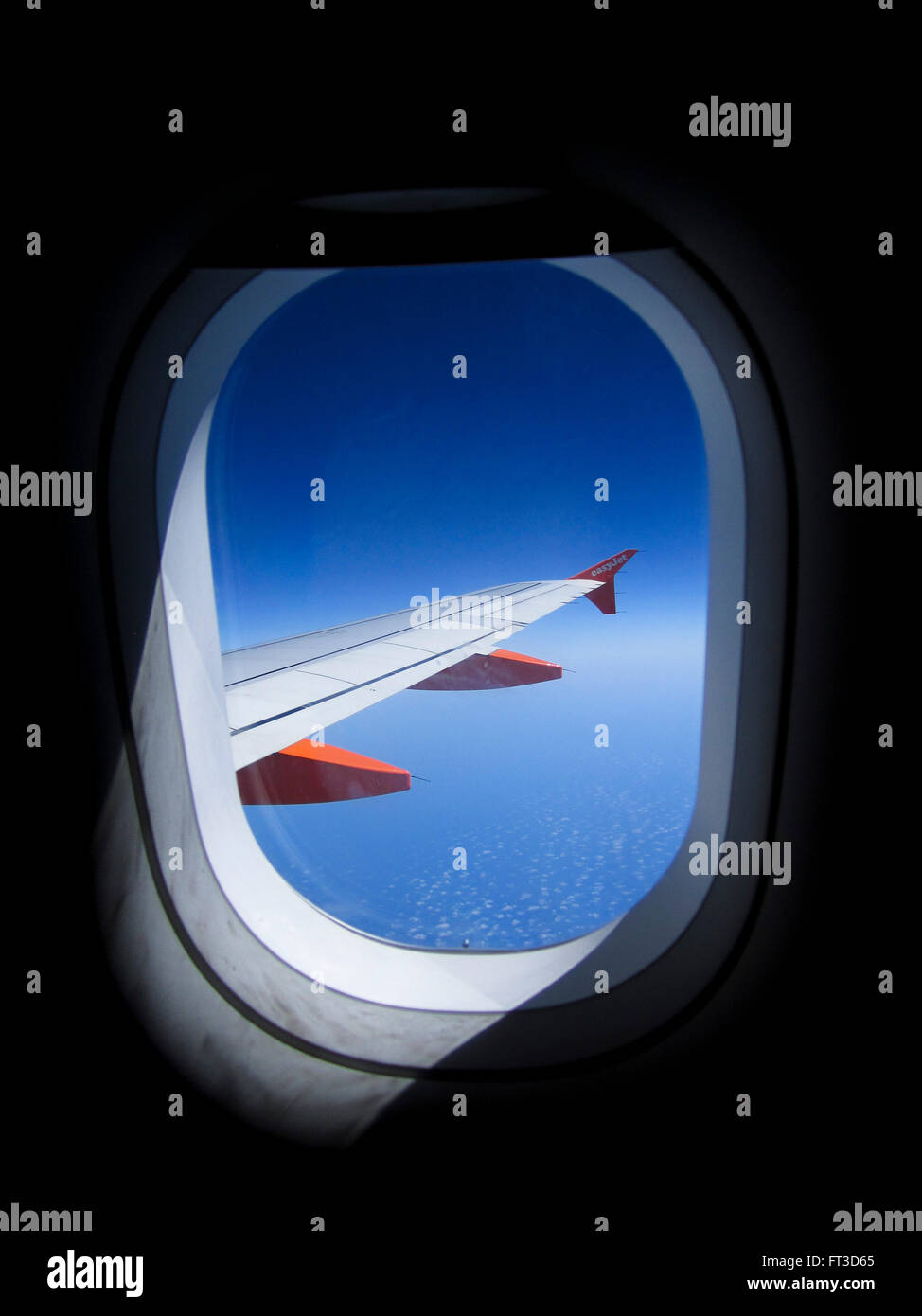 La vista dalla finestra di un aereo o un aereo di linea shwoing l'ala dell'aereo jet e un profondo cielo blu. Foto Stock