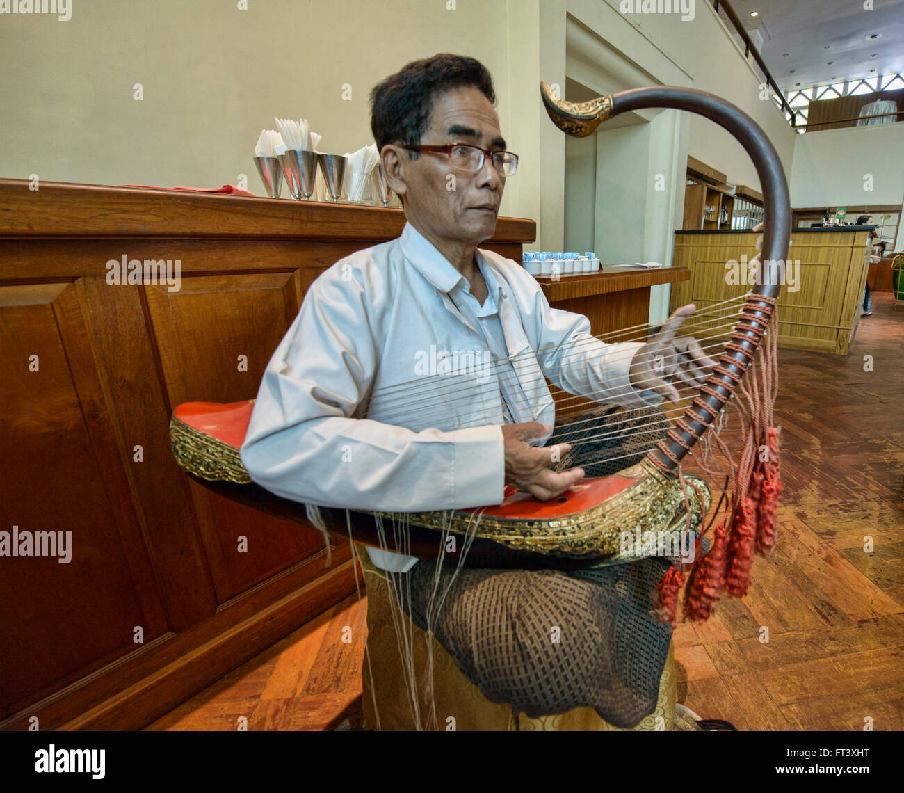 Musicista che gioca una saung, tradizionale birmana arpa arcuata, Yangon, Myanmar Foto Stock