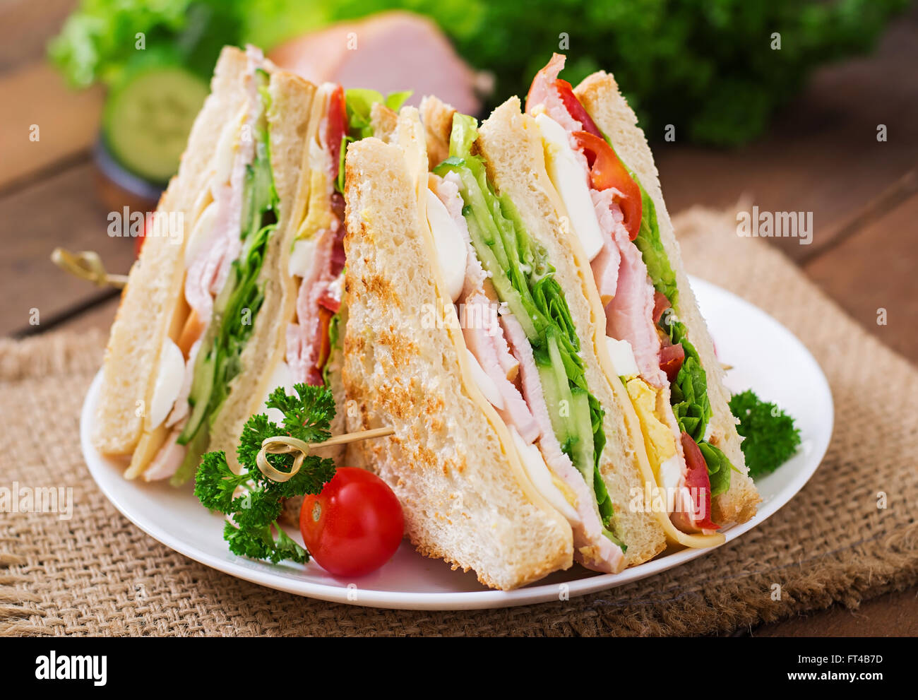 Club sandwich con formaggio, cetriolo, pomodoro, prosciutto e uova. Foto Stock