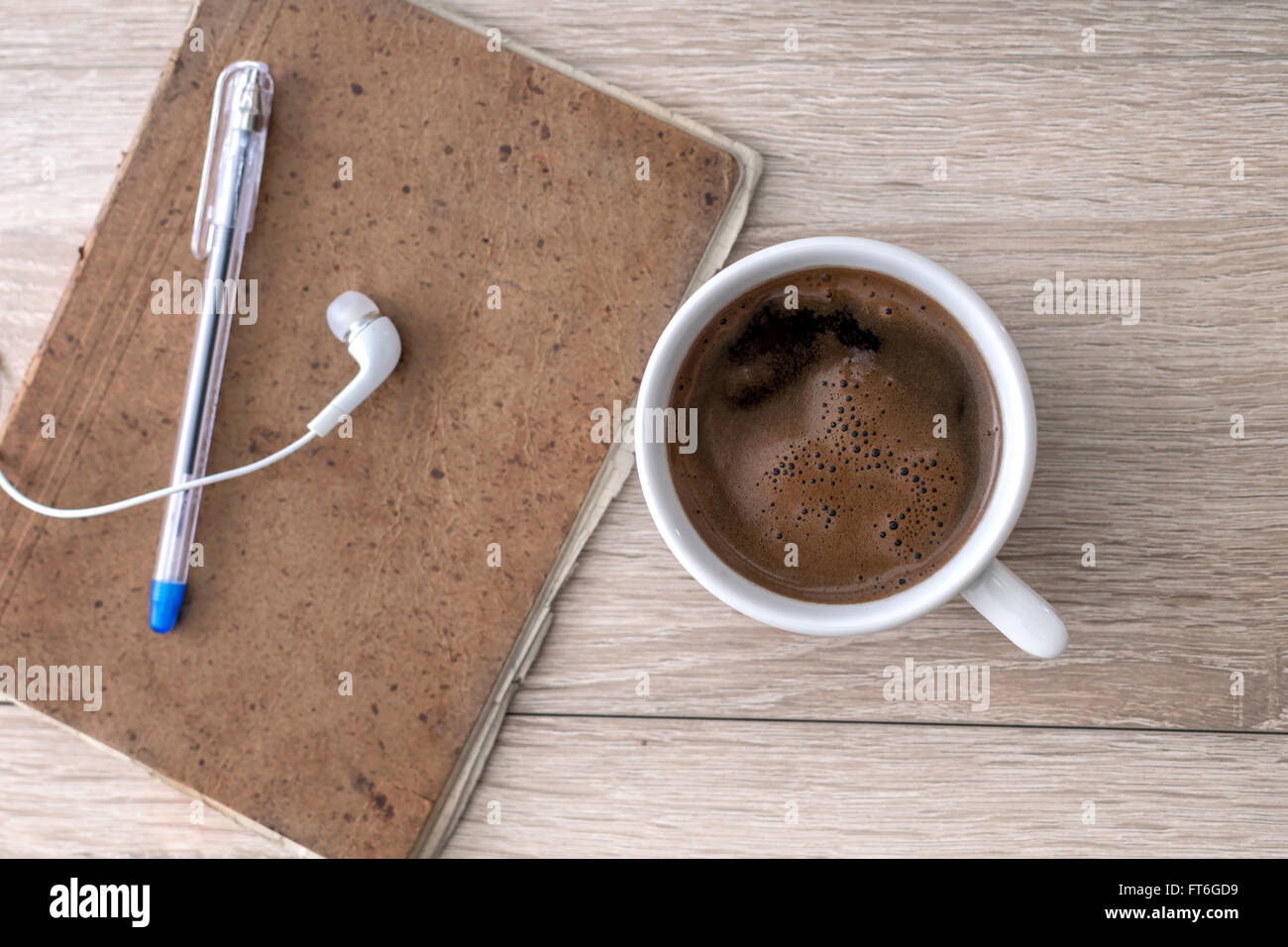 Caffè, notepad, auricolari e matita, sulla scrivania in ufficio. Foto Stock