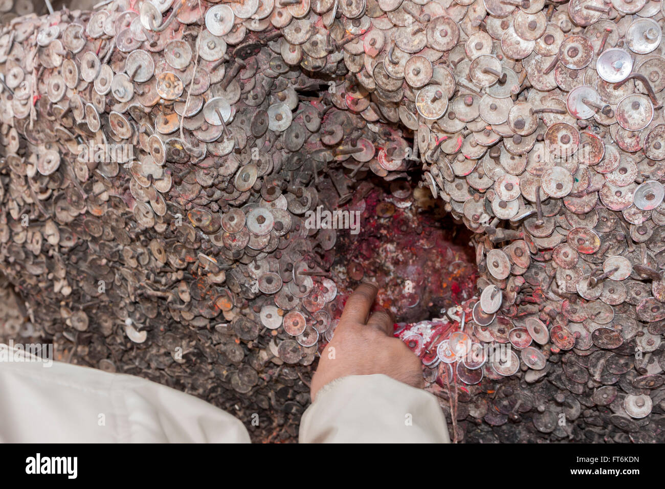 Il Nepal, Kathmandu. Monete lasciate come offerte presso il santuario per il mal di denti Dio, Bangemudha Square. Foto Stock