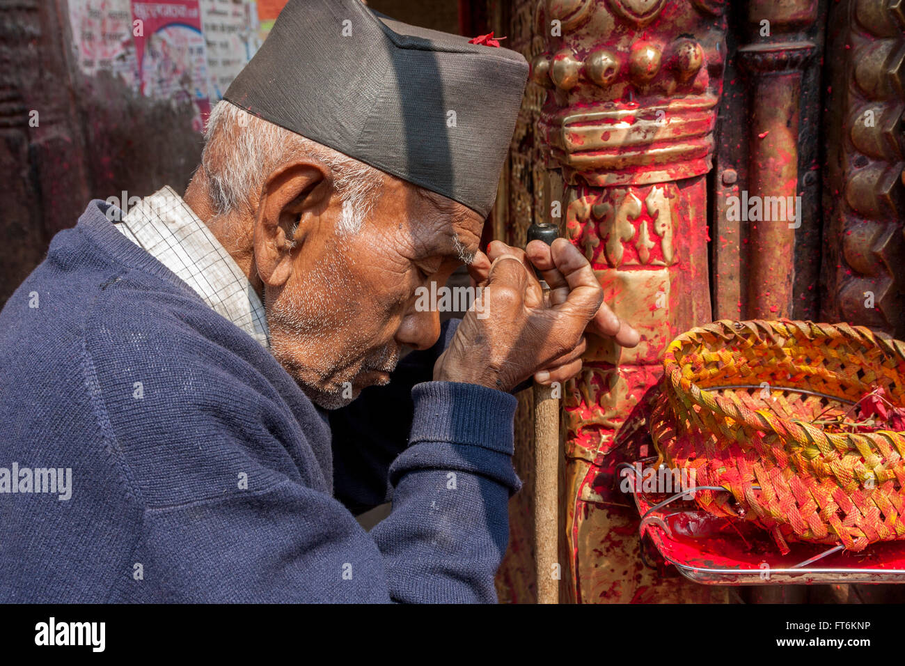 Il Nepal, Kathmandu. Uomo indù applicando Tika di polvere Kumkuma a fronte prima di pregare presso Ashok Binayak (Maru Ganesh) Tempio. Foto Stock