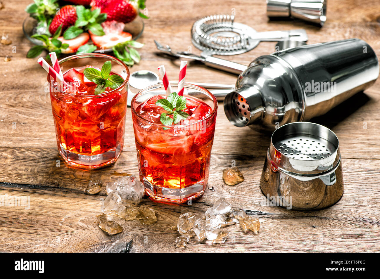 Red drink con ghiaccio. Cocktail bar rendendo gli strumenti, fragola e foglie di menta Foto Stock