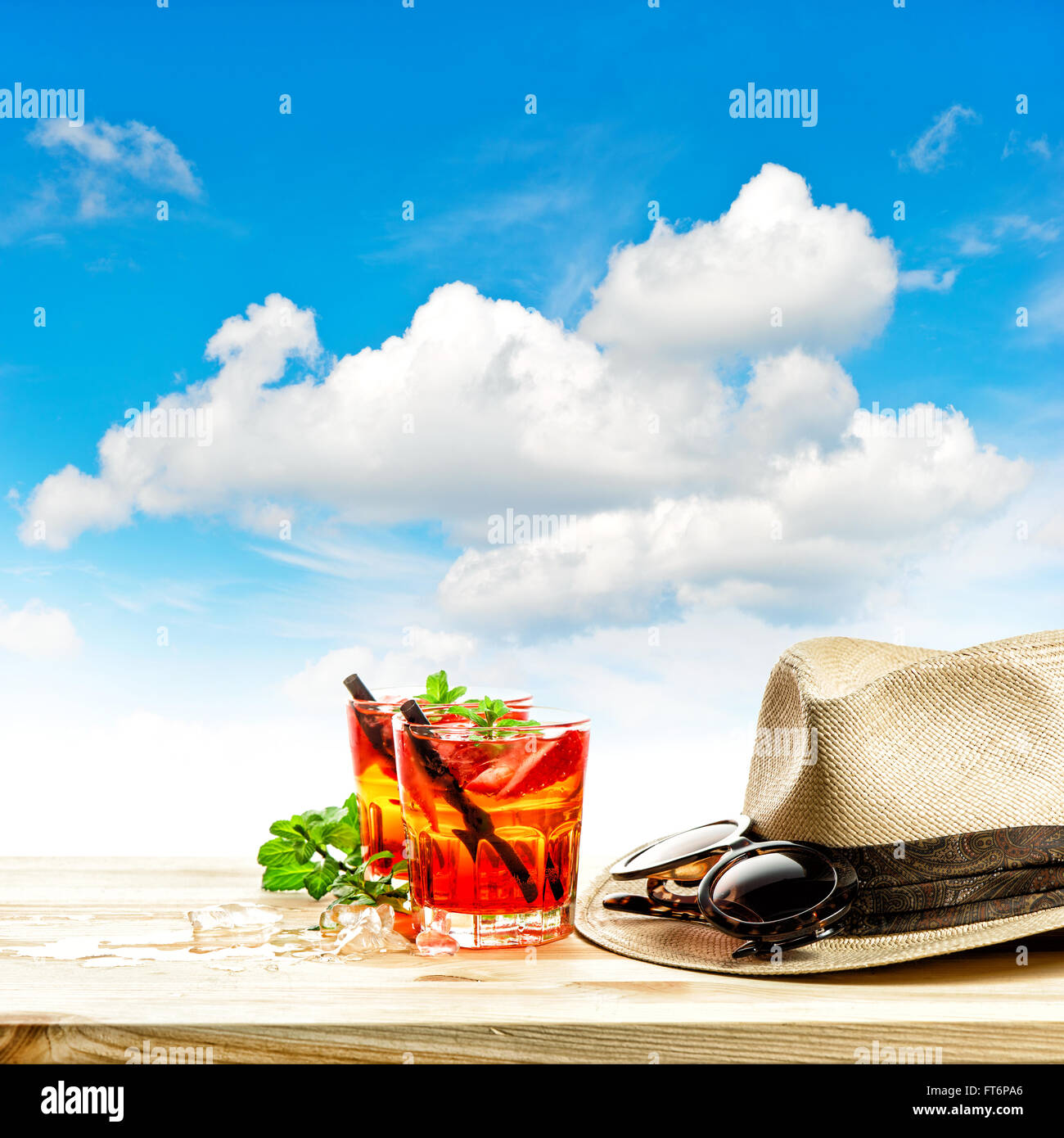 Rosso drink tropicali e verde con foglie di menta. Vacanze estive concetto con cielo blu Foto Stock
