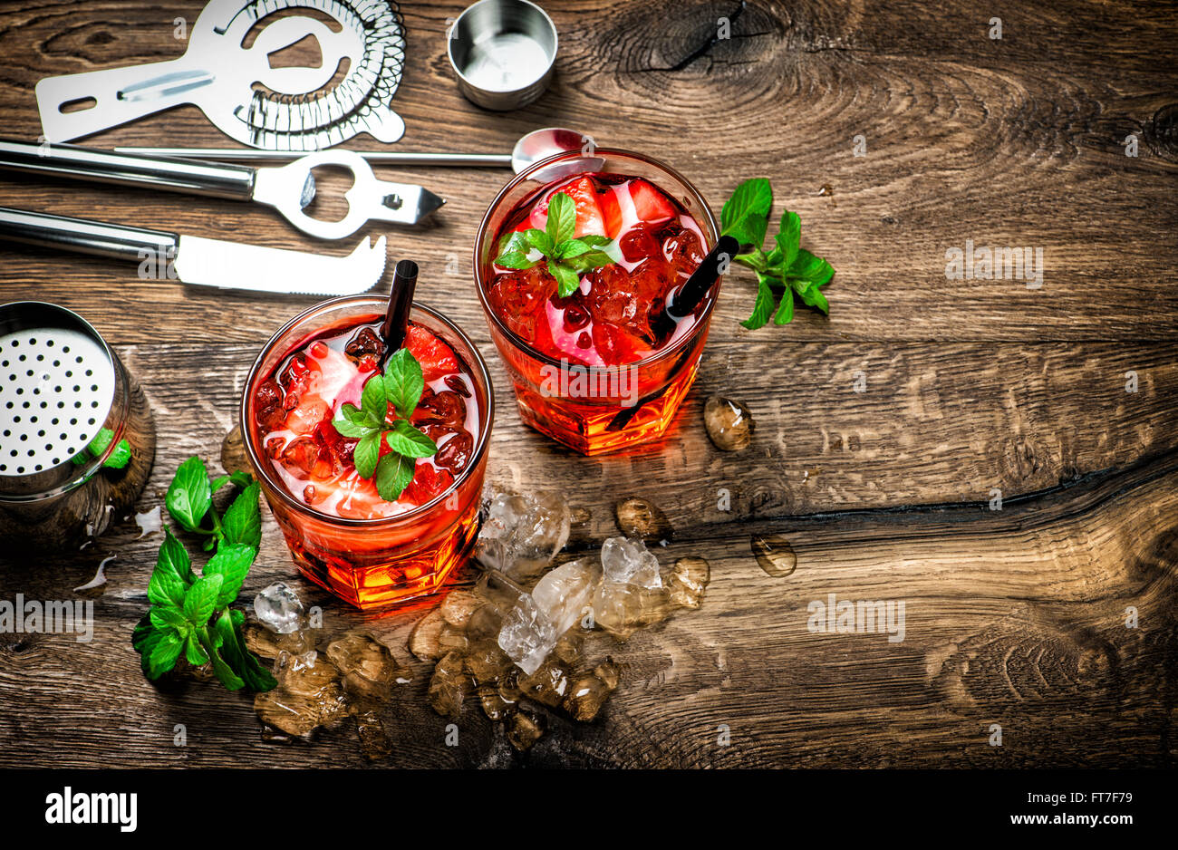 Red drink con ghiaccio, foglie di menta e fragola. Cocktail, campari, aperol, caipirinha, mojito, soda water. Tono scuro foto Foto Stock