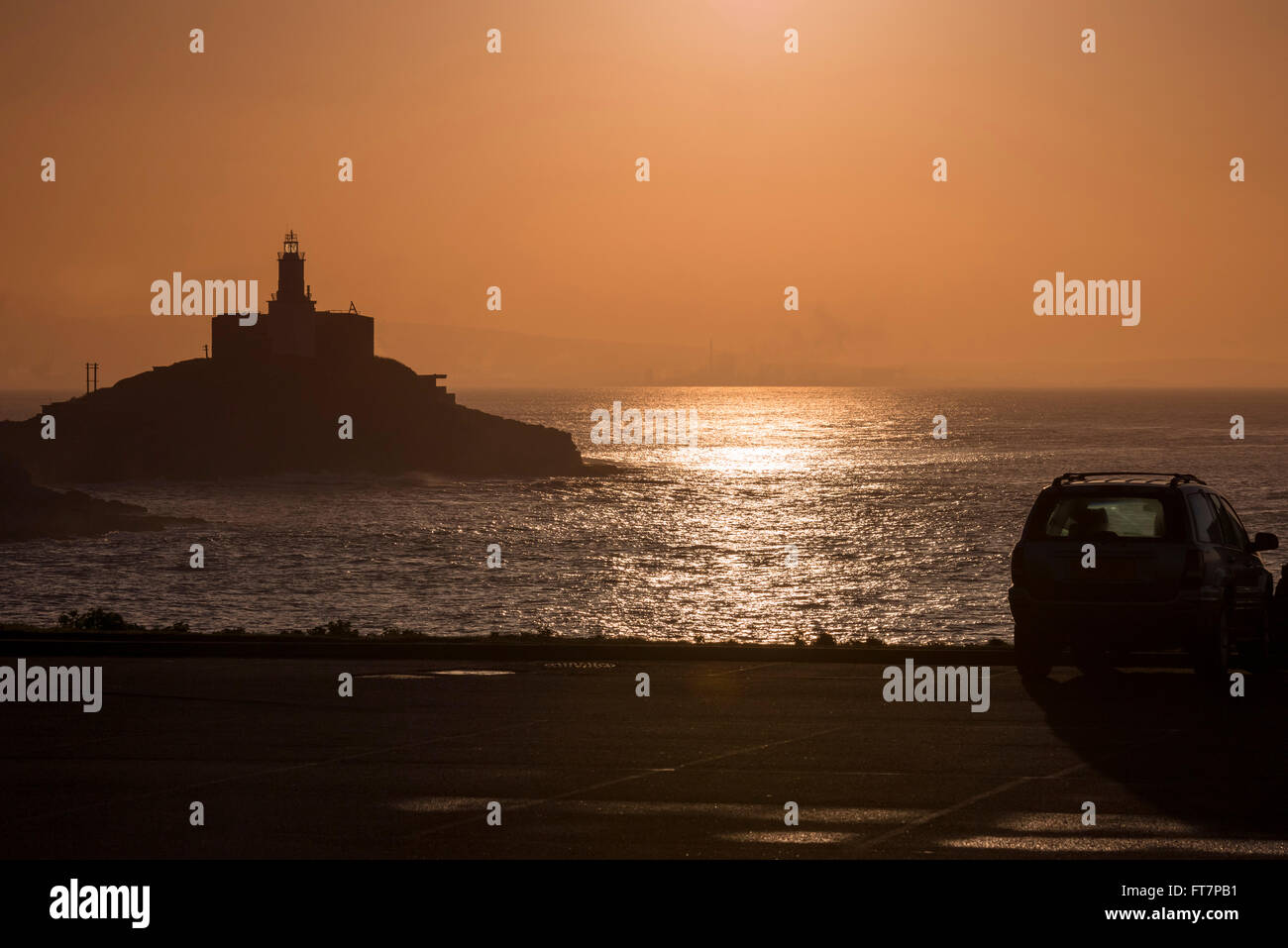 Sunrise a Mumbles lighthouse, bracciale Bay, Wales, Regno Unito. Foto Stock