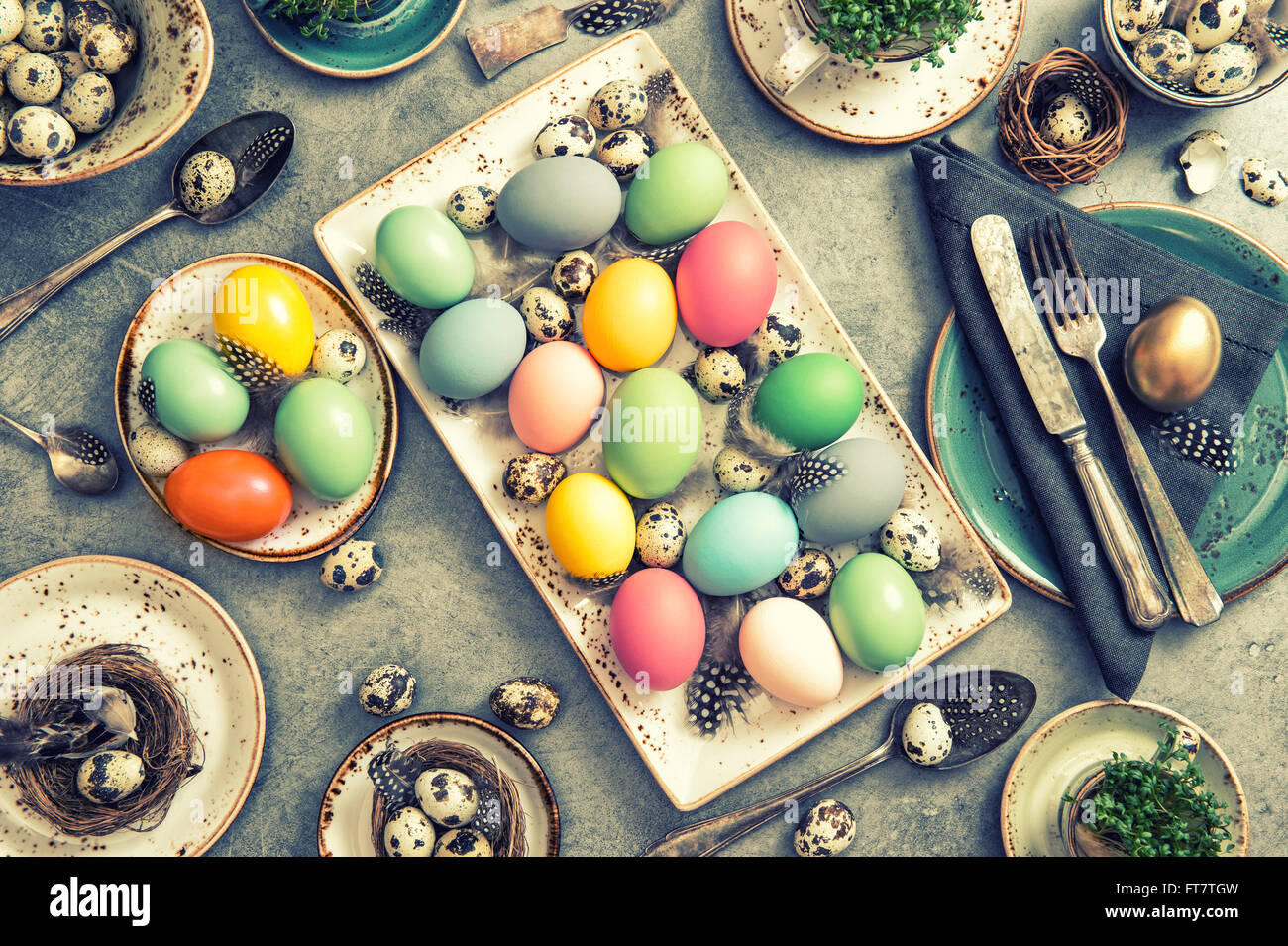 Cena di Pasqua decorazioni per la tavola con uova colorate. In stile vintage tonica foto Foto Stock