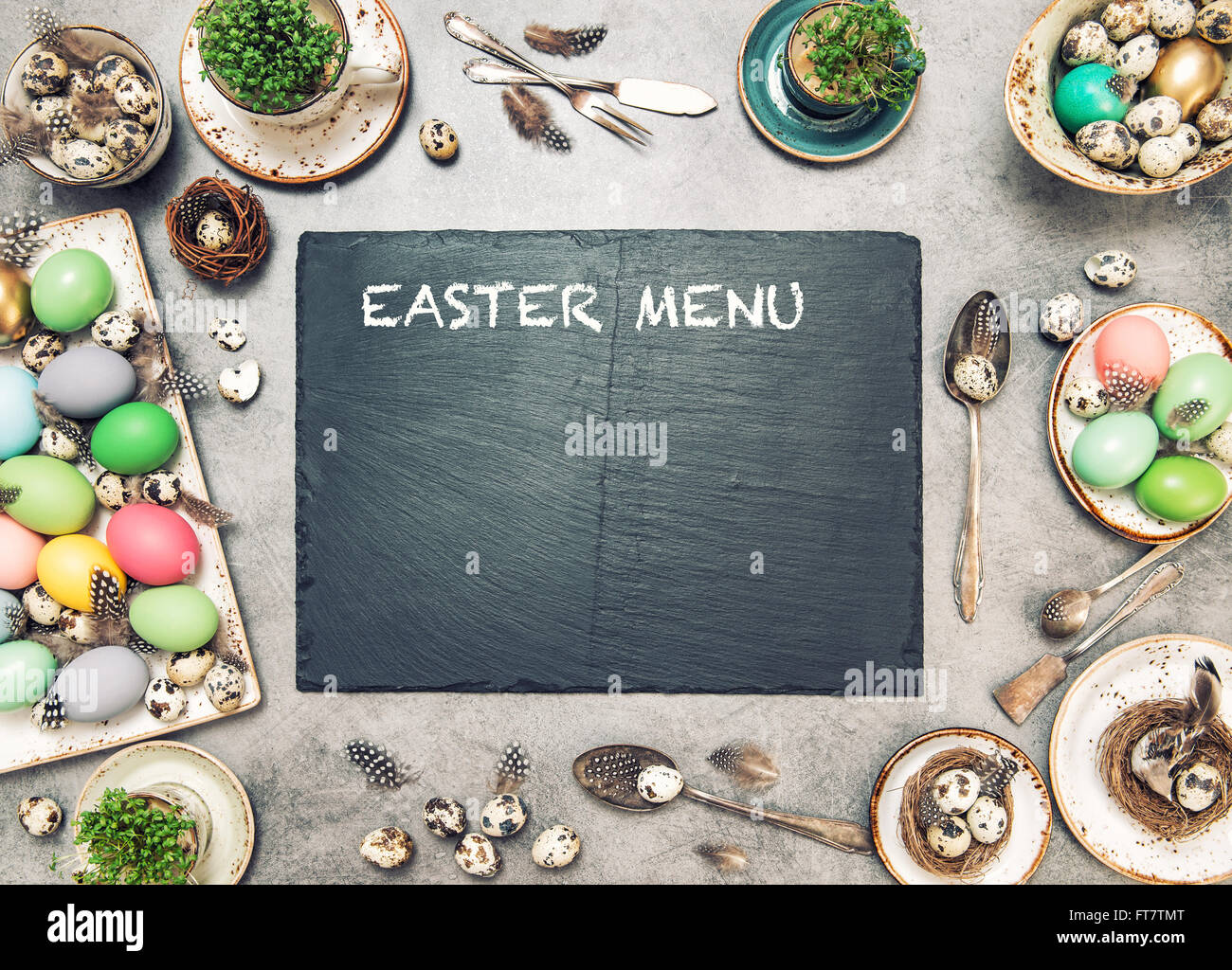 Pasqua decorazioni per la tavola con uova colorate e lastra di pietra. Vacanze a sfondo con spazio per il testo Foto Stock