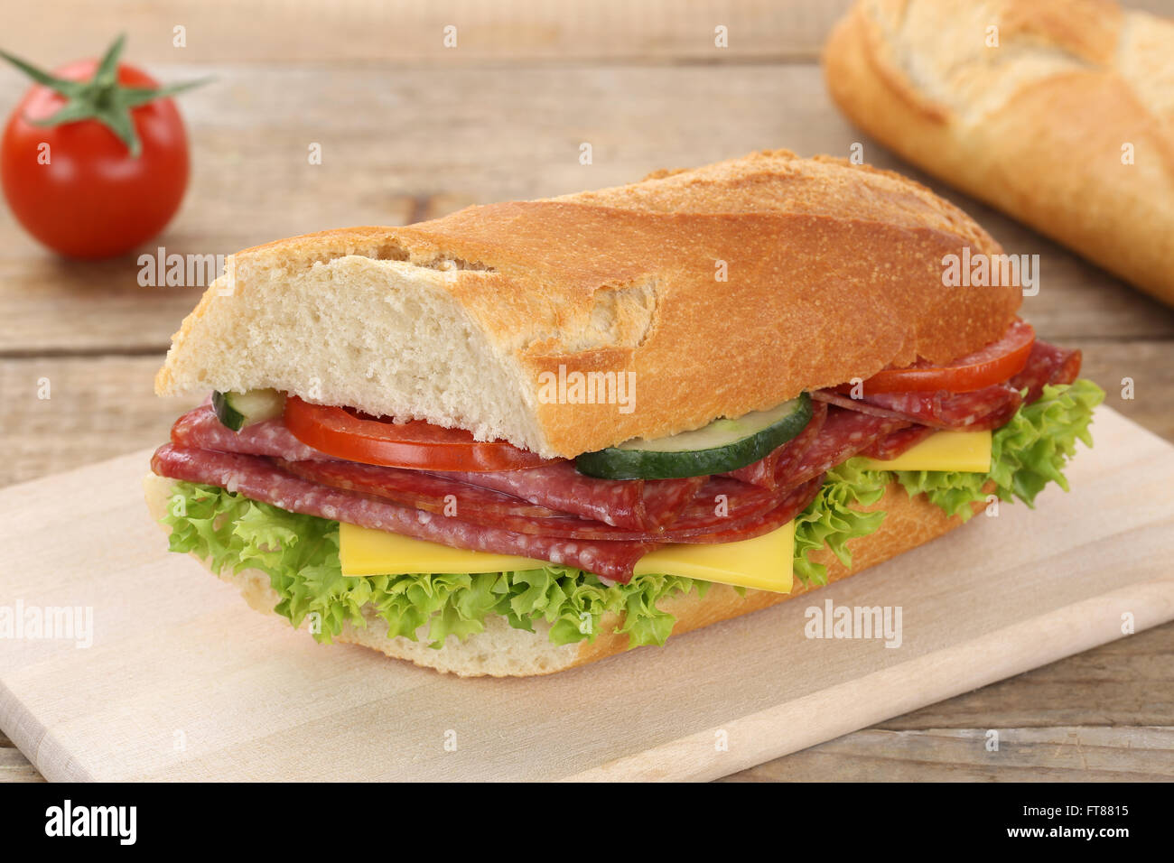Sub baguette sandwich con salame prosciutto, formaggio, pomodori e lattuga per la prima colazione Foto Stock