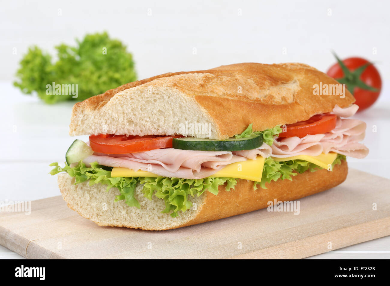 Sub baguette sandwich con prosciutto e formaggio, pomodori e lattuga Foto Stock