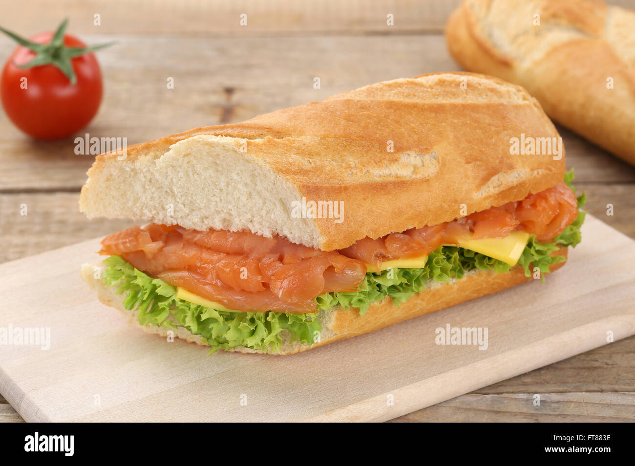 Sub baguette sandwich con salmone pesce, formaggio, pomodori e lattuga per la prima colazione Foto Stock
