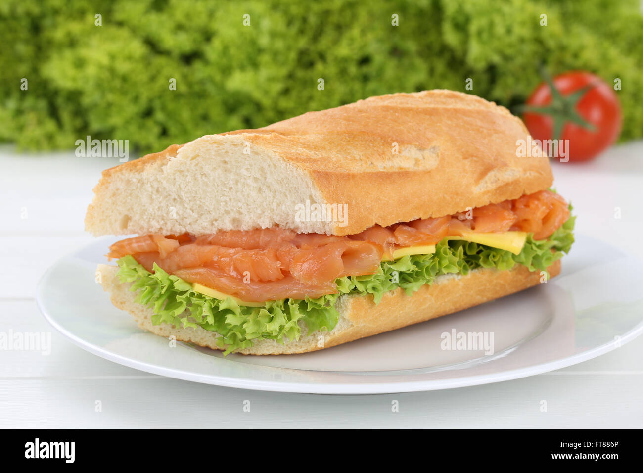 Sub baguette sandwich sulla piastra con salmone pesce, formaggio, pomodori e lattuga per la prima colazione Foto Stock