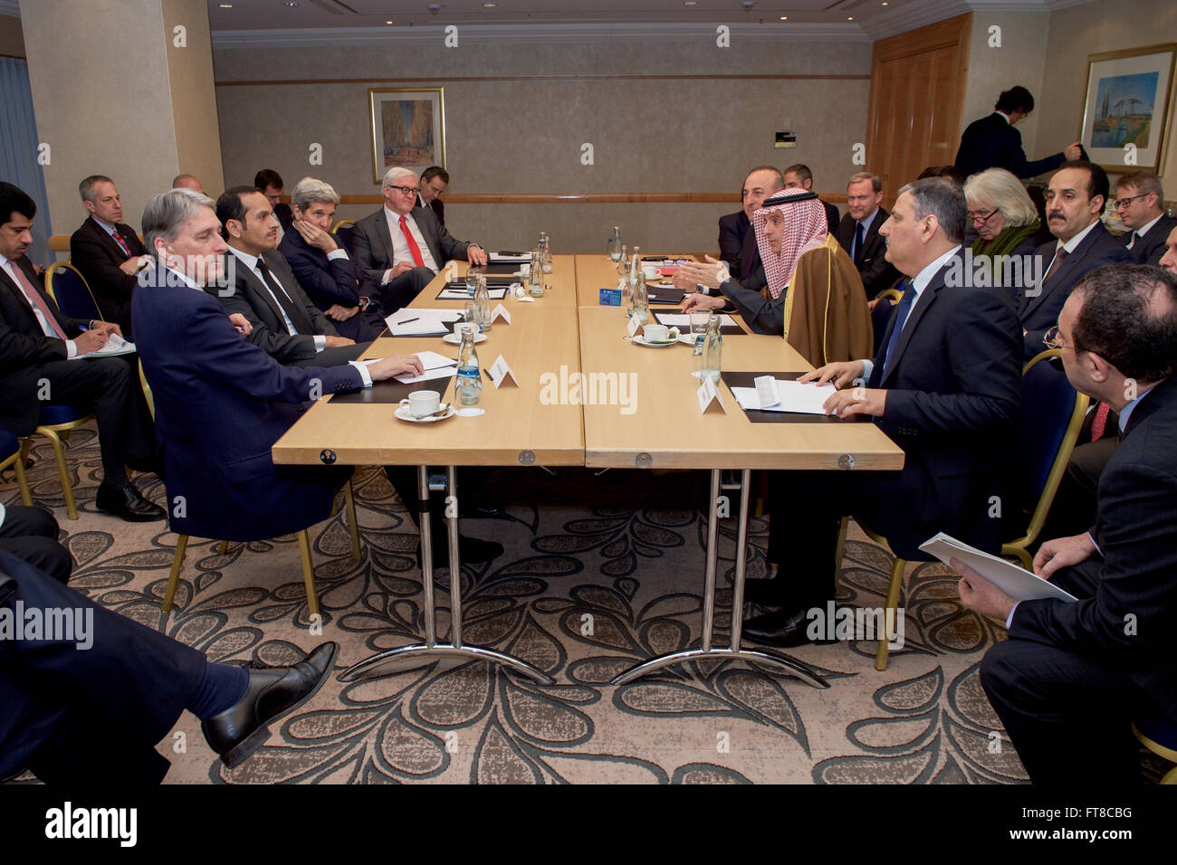 Stati Uniti Il segretario di Stato John Kerry si siede con (in senso antiorario dall'alto) Ministero francese degli Affari Esteri Direttore generale Nicolas de Riviere, ministro degli affari esteri turco Mevlut Cavusoglu, Arabia Saudita il Ministro degli Esteri Adel al-Jubeir, Siriano leader dell opposizione Riyad Hijab, Segretario degli esteri britannico Philip Hammond, Qatar Ministro degli Esteri Mohammed bin Abdulrahman al-Thani, e il Ministro degli esteri tedesco Frank-Walter Steinmeier 11 febbraio 2016, prima di una riunione multilaterale incentrato sulla Siria il precedente in occasione della conferenza di Monaco sulla sicurezza. [Dipartimento di Stato per foto/dominio pubblico] Foto Stock