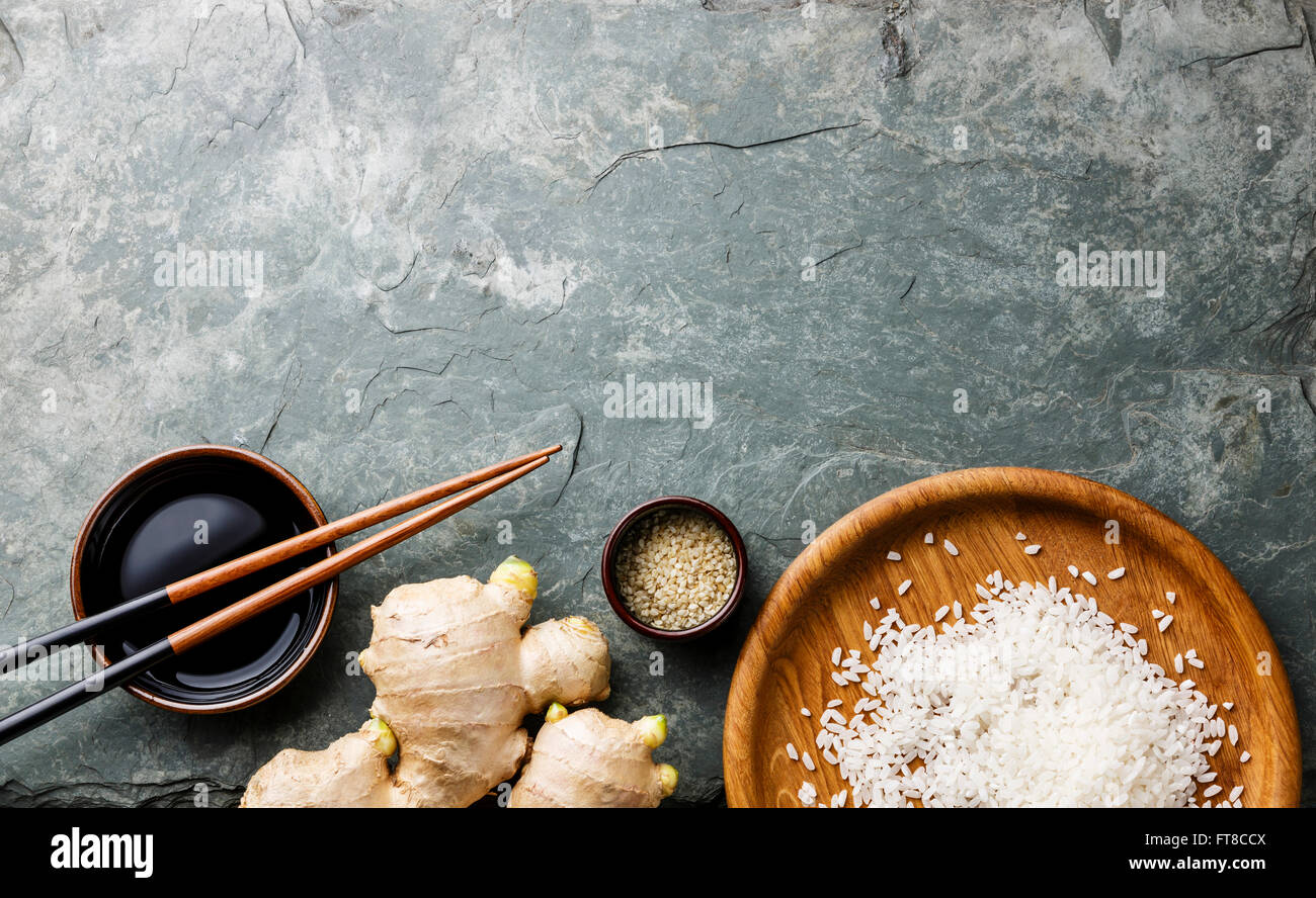 Materie riso bianco, lo zenzero, la salsa di soia e le bacchette di sushi in pietra grigia sullo sfondo di ardesia Foto Stock